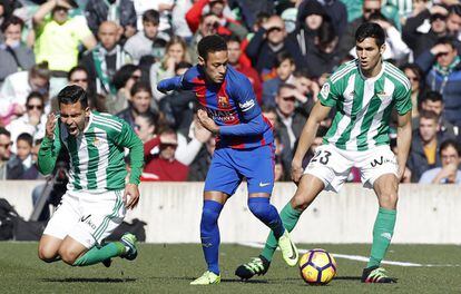 El delantero brasileño del Barcelona, Neymar (centro), controla la pelota ante los jugadores del Betis, Petros Matheus dos Santos (izquierda) y Aissa Mandi (derecha).