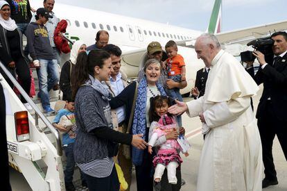 El papa Francisco saluda al grupo de refugiados sirios tras el aterrizaje en el aeropuerto de Ciampino, en Roma, que se ha traído consigo en su visita al campamento de Moria, en la isla de Lesbos (Grecia), el 16 de abril de 2016.
