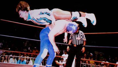 Cassandro salta sobre un rival en un combate de lucha libre mexicana.