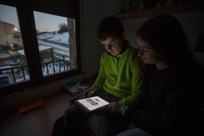 Sergio Terrazas y su hermana Paula consultan uno de sus dispositivos electrónicos en su casa de Molinos de Duero. Los utilizan para hacer los deberes de algunas de sus asignaturas. "A mí me gusta mucho más cuando nos los mandan así", dice Sergio.