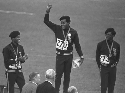 Lee Evans, en el centro, en el momento en que levantó el puño al recoger la medalla de oro por los 400 metros lisos en los juegos de México de 1968.