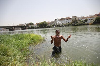 Un joven se refresca en el río Guadalquivir, este jueves, en Sevilla.
