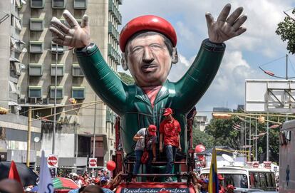 Seguidores del presidente venezolano, Nicolás Maduro, portan un inflable gigante de Chaves en Caracas, este martes.