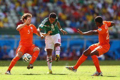 Giovani dos Santos de México, remata y anota el primer gol de su equipo ante Daley Blind (i) y Georginio Wijnaldum.