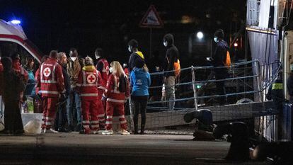 La policía y la Cruz roja atienden a migrantes desembarcados el sábado en el puerto de Catania, en Sicilia.