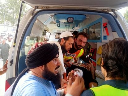 Trabajadores de los servicios de emergencias y voluntarios transportan a uno de los heridos en el atentado en Jar, en Pakistán, el 30 de julio de 2023.