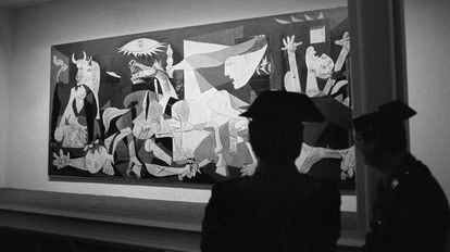 Agentes de la Guardia Civil vigilan la urna blindada que protege el &quot;Guernica&quot;, obra de Pablo Picasso, en su su presentaci&oacute;n en el emplazamiento del Cas&oacute;n del Buen Retiro de Madrid, tras su regreso a Espa&ntilde;a. 