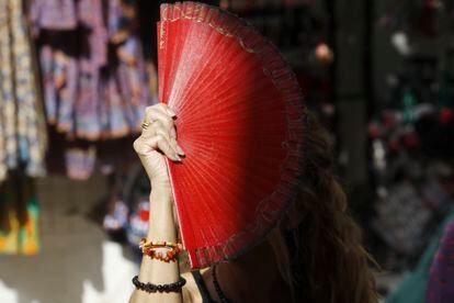 Una mujer se protegía del sol el domingo con un abanico en Córdoba.