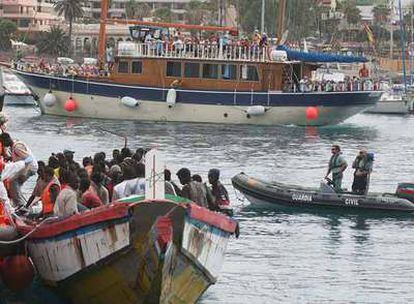 Un lancha de la Guardia Civil escolta una gran barca con 120 inmigrantes que llegó el lunes al muelle de Los Cristianos, en Tenerife.