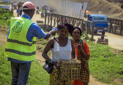 Dos mujeres pasas un control donde se les mide la temperatura como forma de detectar posibles síntomas de ébola, cerca de Kasindi (Congo).
