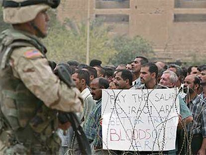 Ex soldados iraquíes con un cartel que dice: "Mejor pagar al Ejército iraquí que pagar con sangre del Ejército de EE UU".