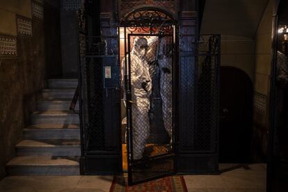 Protegidos con trajes para evitar infecciones, dos trabajadores de una morgue trasladan el cuerpo de un anciano que murió por covid-19 desde una residencia de ancianos en Barcelona, el 13 de noviembre de 2020.