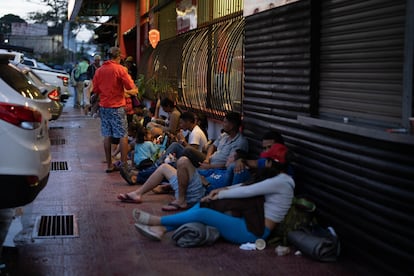 Migrantes venezolanos apartan un lugar en una acera de la capital costarricense.