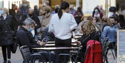 Un camarero atiende las mesas de una cafeteria del barrio de Sants de Barcelona hoy.