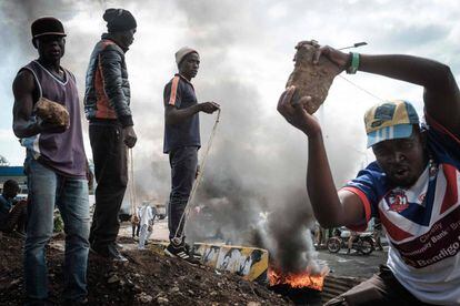 Partidarios del líder de la oposición de Kenia, Raila Odinga, sostienen piedras mientras bloquean una calle de Kisumi durante unas protestas.