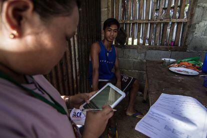 El equipo de Acción contra el Hambre usando un dispositivo móvil en Burauen, Filipinas, para entrevistar a diferentes beneficiarios de sus ayudas para víctimas del tifón Yolanda, en 2014.