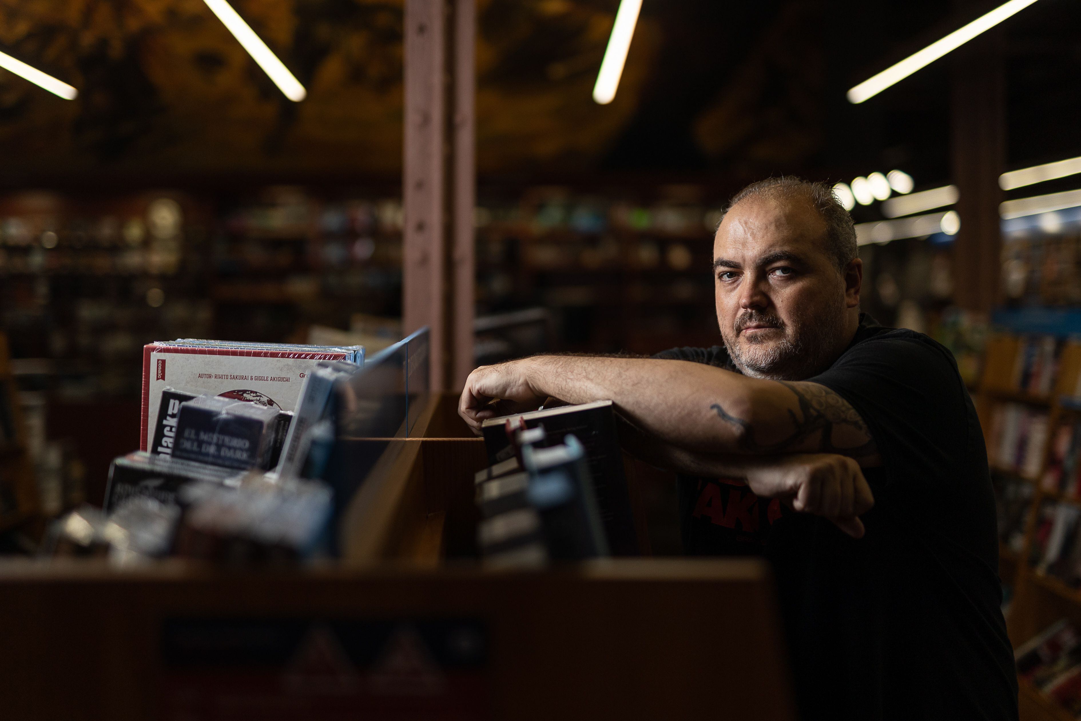 Antonio Torrubia apoyado en una estantería de la libreria Gigamesh de Barcelona.