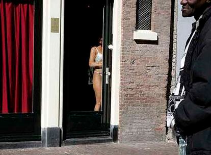 Una prostituta se exhibe ante los transeúntes en un burdel del <i>distrito rojo</i> de Ámsterdam.