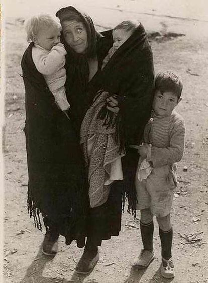 Una mujer pendiente del cielo trata de proteger a sus hijos durante un bombardeo.