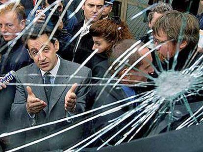 Nicolas Sarkozy contempla el cristal de un camión, fracturado en un enfrentamiento de la policía con jóvenes manifestantes en Estrasburgo.