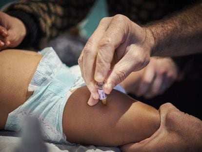 Un pediatra vacuna a un bebé en Francia.