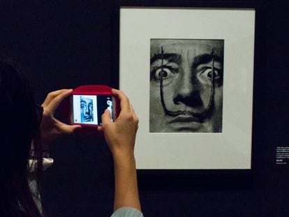 Una visitante toma una foto de una de las im&aacute;genes de la serie que Philippe Halsman hizo sobre los bigotes de Dal&iacute;.