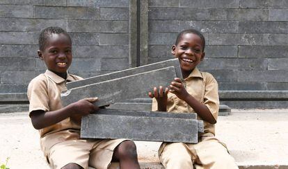 Los estudiantes están contentos de que se esté construyendo una nueva clase en su escuela en Sakassou, en el centro de Costa de Marfil, que estará construida con ladrillos de plástico.