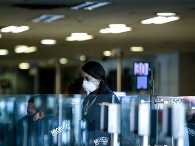 Una trabajadora del aeropuerto de Bogotá utiliza un cubrebocas.