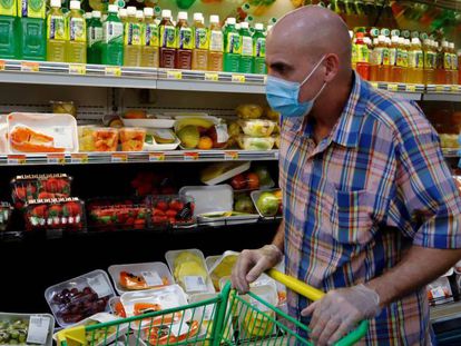 Un hombre usa una máscara de protección mientras realiza compras en un supermercado de San Juan, Puerto Rico. 