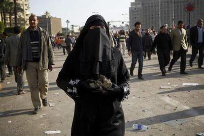 Una mujer armada con piedras en los enfrentamientos de ayer en la plaza de la Liberación, en El Cairo.