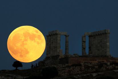 Una luna llena se levanta detrás del Templo de Poseidón antes de un eclipse lunar en el Cabo Sounion, cerca de Atenas, Grecia.