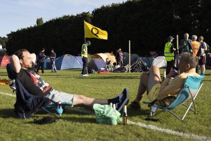Dos aficionados descansan en la zona de acampada de Wimbledon, el lunes 27 de junio.
