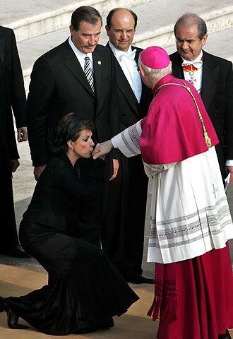 La primera dama de México, Marta Sahagún, besa la mano del arzobispo británico James Harvey ante el presidente mexicano, Vicente Fox.