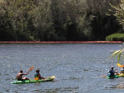 Varios pirag&uuml;istas pasan por la zona donde est&aacute; el filtro contra el caracol manzana, a la altura de Miravet en el r&iacute;o Ebro.