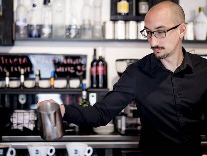 Un cambrer prepara tres caf&egrave;s en una cafeteria de Madrid.