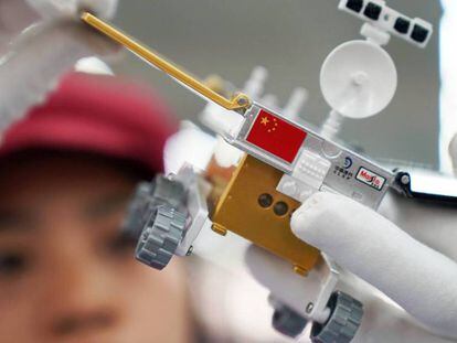 Un trabajador inspecciona un modelo miniatura del vehículo lunar para la sonda china Chang'e 4, en una fábrica en Dongguan, China. 