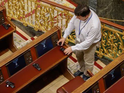 Un técnico coloca los auriculares de traducción en el hemiciclo del Congreso de los Diputados, este martes.