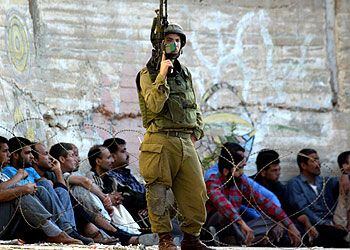 Un soldado irsraelí custodia a detenidos palestinos en un campo de refugiados de Nablús.