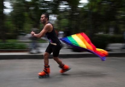 Un hombre patina con una bandera arcoíris, símbolo de la comunidad LGTBI, para celebrar la diversidad sexual, en la Ciudad de México, en 2021.