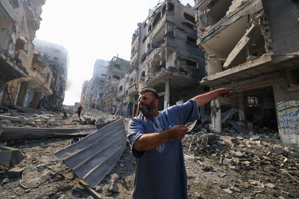 Un palestino señala a un edificio destruido por los bombardeos en Ciudad de Gaza, este miércoles.