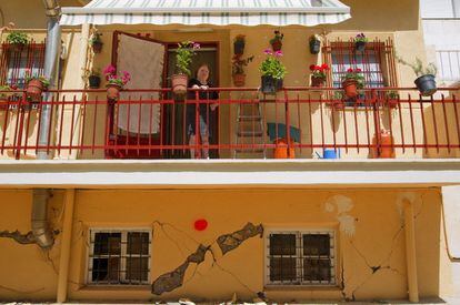 Una vecina de Lorca en el balcón de su vivienda, a pesar de estar marcada con un punto de color rojo como alarma de vivienda inhabitable.