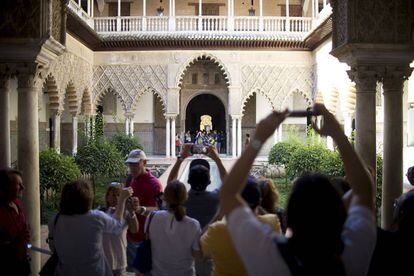 Varios turistas toman fotografías de uno de los patios del Alcázar de Sevilla.