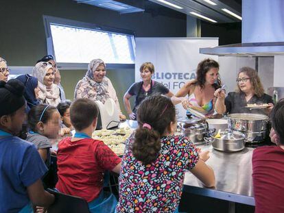 Mares amb nens durant un curs de cuina a la biblioteca Fondo de Santa Coloma de Gramenet. 