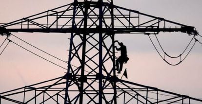 Un operario repara una torreta eléctrica.