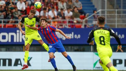 El futbolista del Girona Santi Bueno (I) lucha por el balón con Blanco Leschuk (C), del Eibar, durante el partido de vuelta de la primera eliminatoria de los play offs de ascenso a LaLiga Santander entre el Eibar y el Girona.