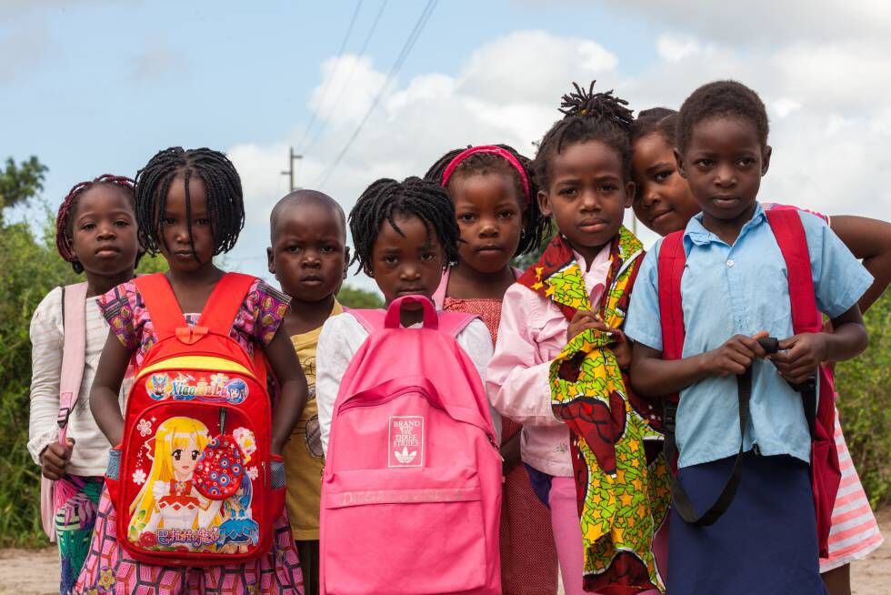 Un grupo de niñas y niños posa camino de la escuela, en Manhiça.