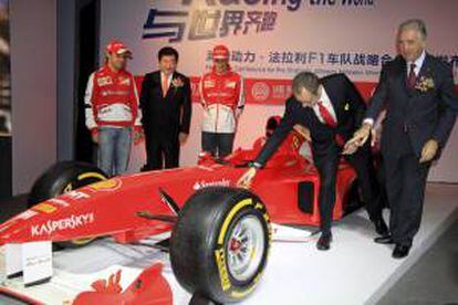 Los pilotos de Ferrari Felipe Massa (i) y Fernando Alonso (31), Tan Xuguang (2i), presidente ejecutivo de Weichai Power y Piero Ferrari, vicepresidente de Ferrari SpA, durante la presentación de la alianza publicitaria entre la firma china y la escudería en Shanghái.