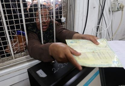 Una mujer palestina presentaba su tarjeta de racionamiento para recibir sacos de harina distribuidas por la Agencia de la ONU para los Refugiados Palestinos (UNRWA), este lunes en Jan Yunis. 