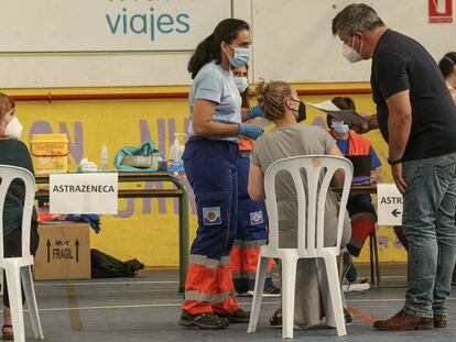 Dos profesores entregan el consentimiento informado para vacunarse con Pfizer en el pabellón polideportivo de Gines (Sevilla).