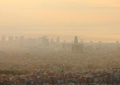 Vista aérea de Barcelona, con la Sagrada Familia y la Torre Agbar en el centro, apenas visibles por la contaminación atmosférica. |